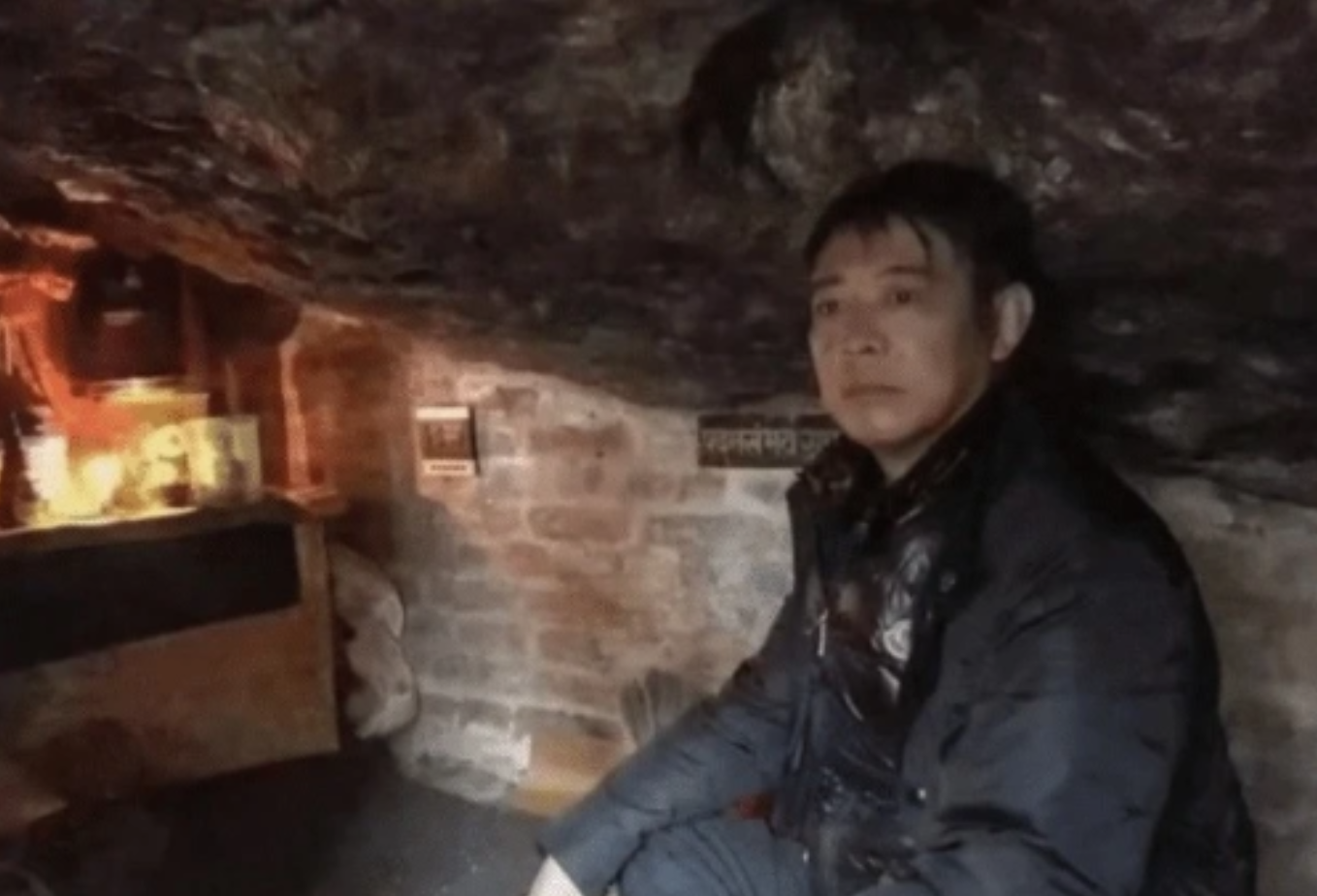 57岁李连杰在山洞打坐，两眼放空神情落寞，衣着邋遢一身泥土灰尘