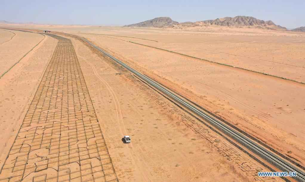 Aerial photo shows workers driving along Linhe-Ceke railway in north China's Inner Mongolia Autonomous Region, April 14, 2021. With a total length of 768 kilometers, the Linhe-Ceke railway is one of the important junctions connecting Mongolia and China. Two passenger trains and nearly 40 freight trains run on it every day. In order to control the sand damage, eleven sand control stations have been set up along the Linhe-Ceke railway that traverses more than 400 kilometers of desert. The railway sand control workers are stationed here all year round to prevent the accumulation of quicksand on the railway lines and ensure the smooth railway transportation. (Xinhua/Lian Zhen)