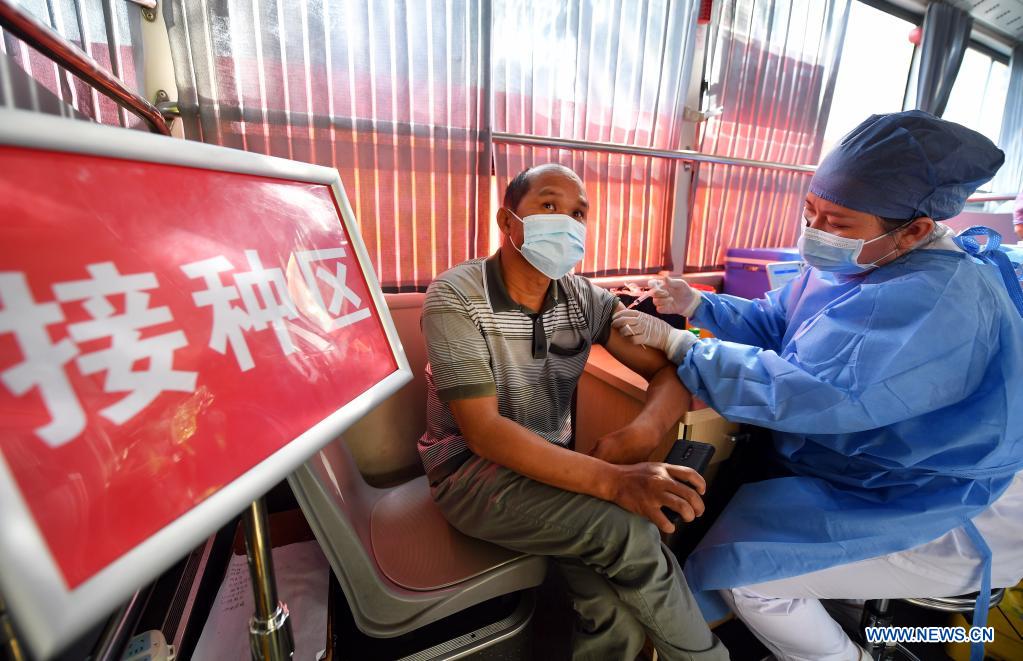 A health worker administers a dose of COVID-19 vaccine for a recipient at a mobile vaccination station in Qiongshan District of Haikou, south China's Hainan Province, April 15, 2021. Vaccination against COVID-19 has been made easier for Haikou residents as 20 bus-turned mobile vaccination stations were recently introduced at the service of vaccine recipients in need. (Xinhua/Guo Cheng)