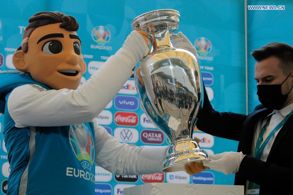 A person dressed as the mascot of the EURO 2020 soccer tournament holds the trophy of the tournament during a presentation in Bucharest, Romania, April 25, 2021. The EURO 2020 soccer tournament was postponed to 2021 due to COVID-19 pandemic. Bucharest will host three matches of Group C and one from the round of 16 at the National Arena. (Photo by Cristian Cristel/Xinhua)