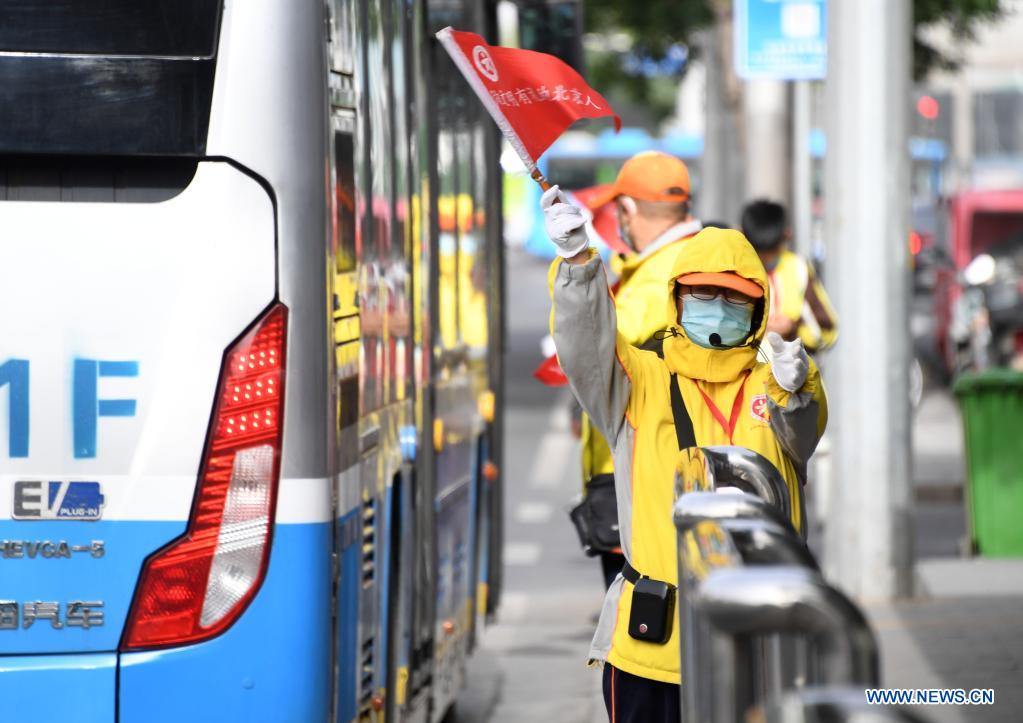 A volunteer directs a bus to the station in Beijing, capital of China, May 6, 2021. Floating sand and dust affected Beijing from Thursday noon time. (Xinhua/Ren Chao)