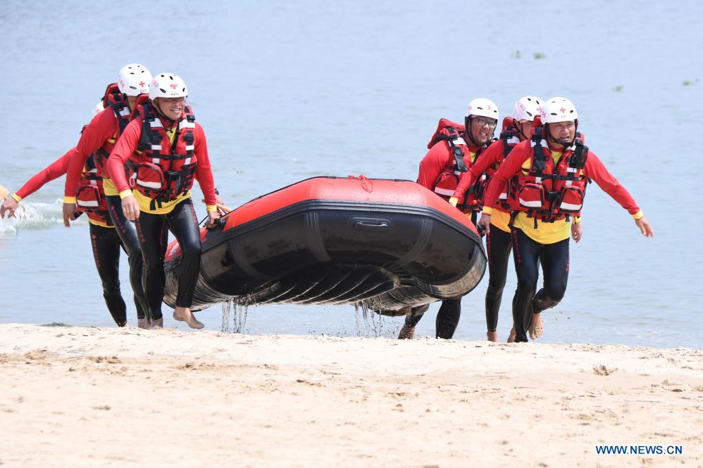 Rescuers from a Red Cross rescue team participate in an aquatic lifesaving exercise during an emergency rescue drill in Fuzhou, capital of southeast China's Fujian Province, May 10, 2021. A comprehensive emergency rescue drill hosted by the Red Cross Society of China was held in Fuzhou on Monday. A total of 13 Red Cross rescue teams from all over the country and the Donghai No.2 flying rescue service participated in the drill and systematically exercised rescue subjects like aquatic lifesaving, search and rescue, medical treatment, water supply and etc., in an effort to improve the joint rescue capability of various rescue teams at different levels. (Xinhua/Jiang Kehong)