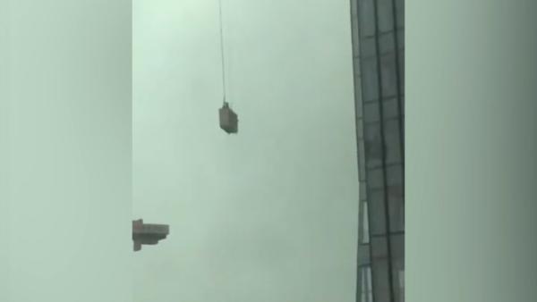武汉暴雨工地吊篮高空摇摆撞向高楼,篮内两名工人被救下