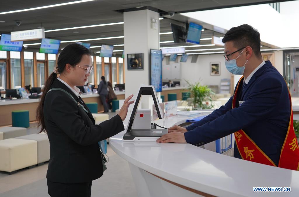 A citizen goes through facial recognition and takes a queuing number at the information desk of the Xiongan New Area Administrative Service Center in Xiongan New Area, north China's Hebei Province, May 12, 2021. Founded on May 30 of 2018 and composed of different functional areas, the Xiongan New Area Administrative Service Center acts as a 