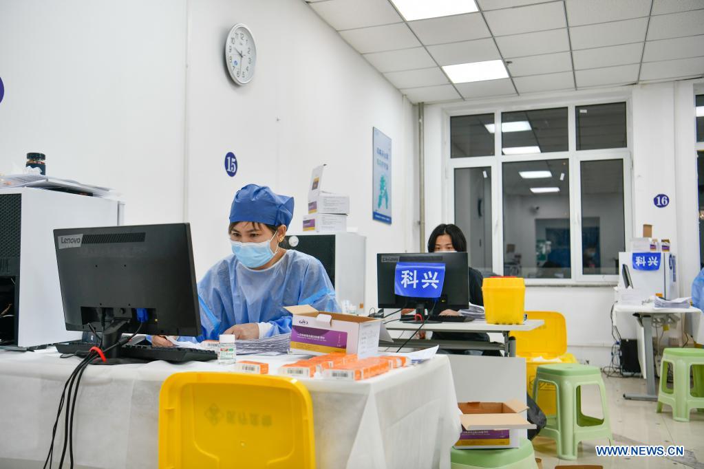 Medical workers check the information of vaccination at a vaccination site in Nankai District, north China's Tianjin, May 12, 2021. A temporary vaccination site was launched to administer the second dose of COVID-19 vaccine for more than 1,000 deliverymen at Hongqi South Road of Nankai District, north China's Tianjin. The vaccination was arranged at night, in order not to affect the couriers' delivery work during the daytime. (Xinhua/Sun Fanyue)