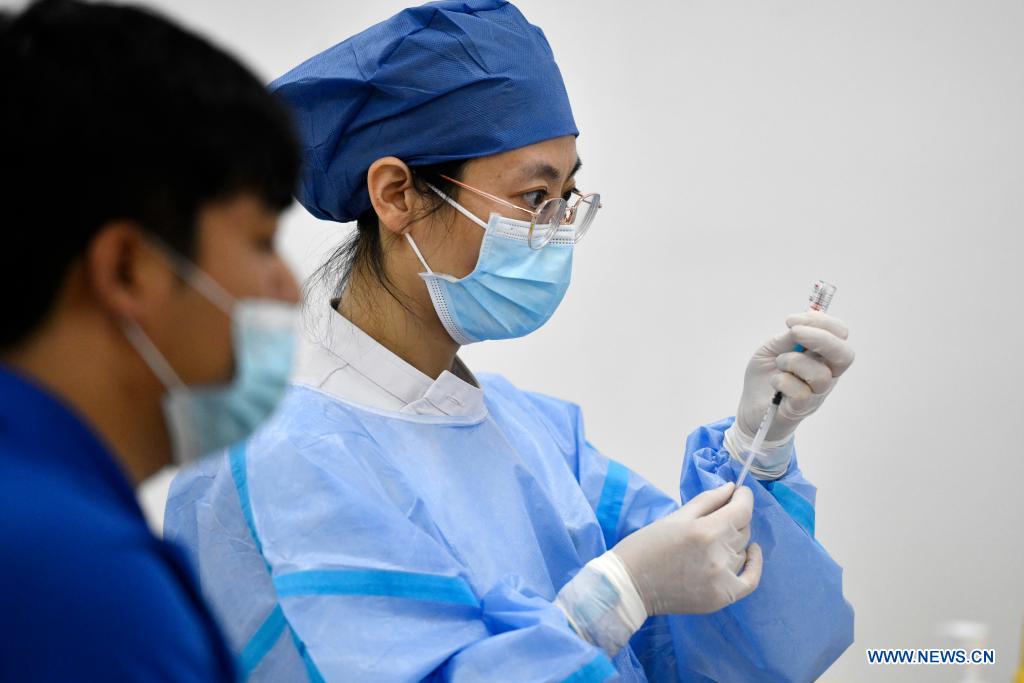 A medical worker prepares a dose of COVID-19 vaccine at a vaccination site in Nankai District, north China's Tianjin, May 12, 2021. A temporary vaccination site was launched to administer the second dose of COVID-19 vaccine for more than 1,000 deliverymen at Hongqi South Road of Nankai District, north China's Tianjin. The vaccination was arranged at night, in order not to affect the couriers' delivery work during the daytime. (Xinhua/Zhao Zishuo)