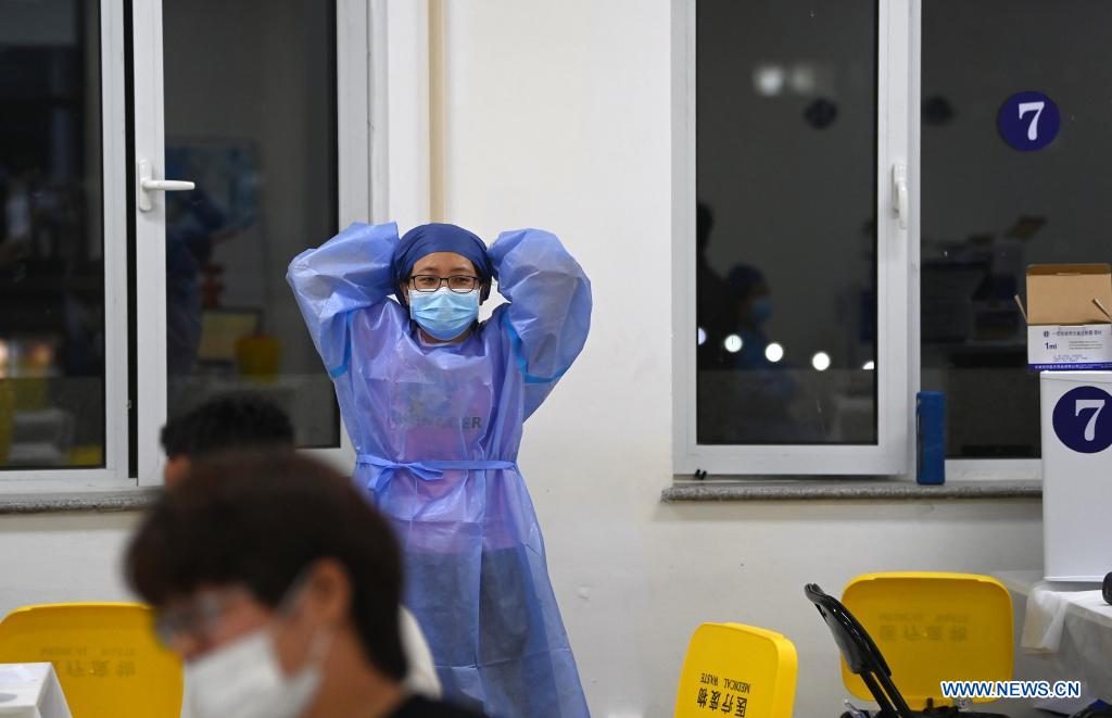 A medical worker takes a rest at a vaccination site in Nankai District, north China's Tianjin, May 12, 2021. A temporary vaccination site was launched to administer the second dose of COVID-19 vaccine for more than 1,000 deliverymen at Hongqi South Road of Nankai District, north China's Tianjin. The vaccination was arranged at night, in order not to affect the couriers' delivery work during the daytime. (Xinhua/Li Ran)