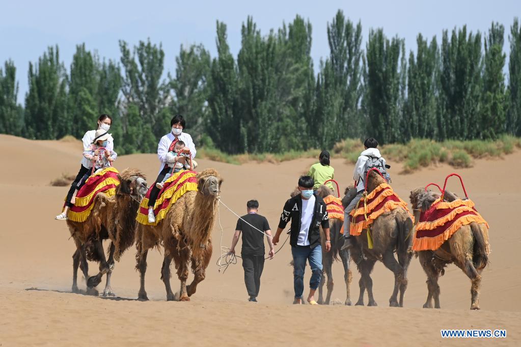 Visitors ride camels in Kumtag Desert in Shanshan County, northwest China's Xinjiang Uygur Autonomous Region, May 16, 2021. The county sees boom in desert tourism early May. (Xinhua/Ding Lei)