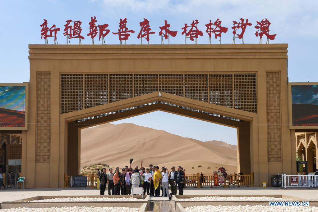 Visitors pose for photos at the entrance of Kumtag Desert in Shanshan County, northwest China's Xinjiang Uygur Autonomous Region, May 15, 2021. The county sees boom in desert tourism early May. (Xinhua/Ding Lei)