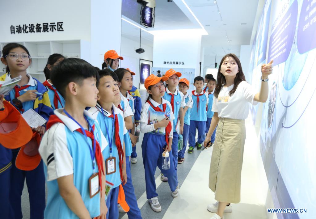 A staff member introduces the laser industry to students of Linhai Road Primary School at Cangzhou Laser Industry Park in Cangzhou, north China's Hebei Province, May 25, 2021. During the National Science and Technology Week, students of Linhai Road Primary School visited Cangzhou Laser Insdustry Park to experience laser technologies and learn about industry robots. (Xinhua/Luo Xuefeng)