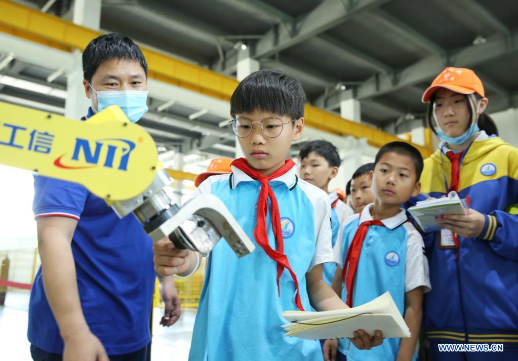 Students of Linhai Road Primary School experience industry robot technologies at Cangzhou Laser Industry Park in Cangzhou, north China's Hebei Province, May 25, 2021. During the National Science and Technology Week, students of Linhai Road Primary School visited Cangzhou Laser Insdustry Park to experience laser technologies and learn about industry robots. (Xinhua/Luo Xuefeng)