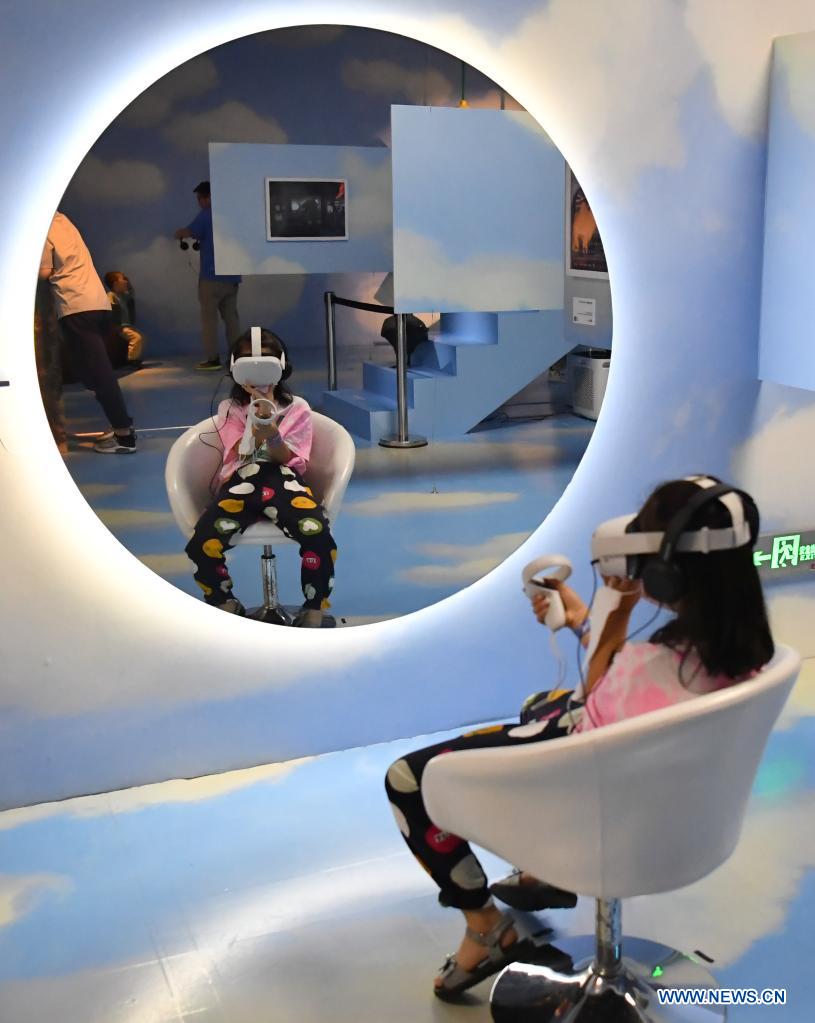 A girl tries a VR equipment during an art festival themed on science and technology in Xi'an, northwest China's Shaanxi Province, June 6, 2021. (Xinhua/Shao Rui)