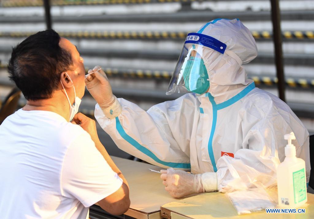 A medical worker collects a swab sample from a resident for COVID-19 nucleic acid testing in Liwan District of Guangzhou, south China's Guangdong Province, June 8, 2021. A new round of mass testing in high-risk areas of Baihedong Street and Zhongnan Street in Guangzhou started on Tuesday. (Xinhua/Deng Hua)