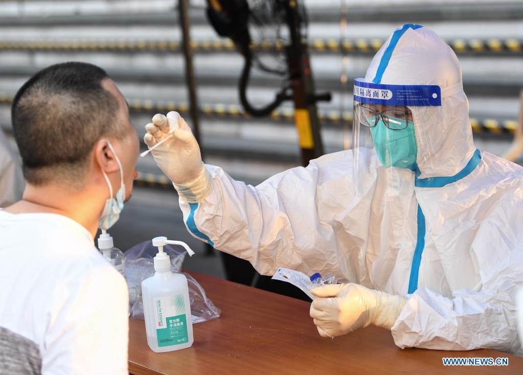 A medical worker collects a swab sample from a resident for COVID-19 nucleic acid testing in Liwan District of Guangzhou, south China's Guangdong Province, June 8, 2021. A new round of mass testing in high-risk areas of Baihedong Street and Zhongnan Street in Guangzhou started on Tuesday. (Xinhua/Deng Hua)