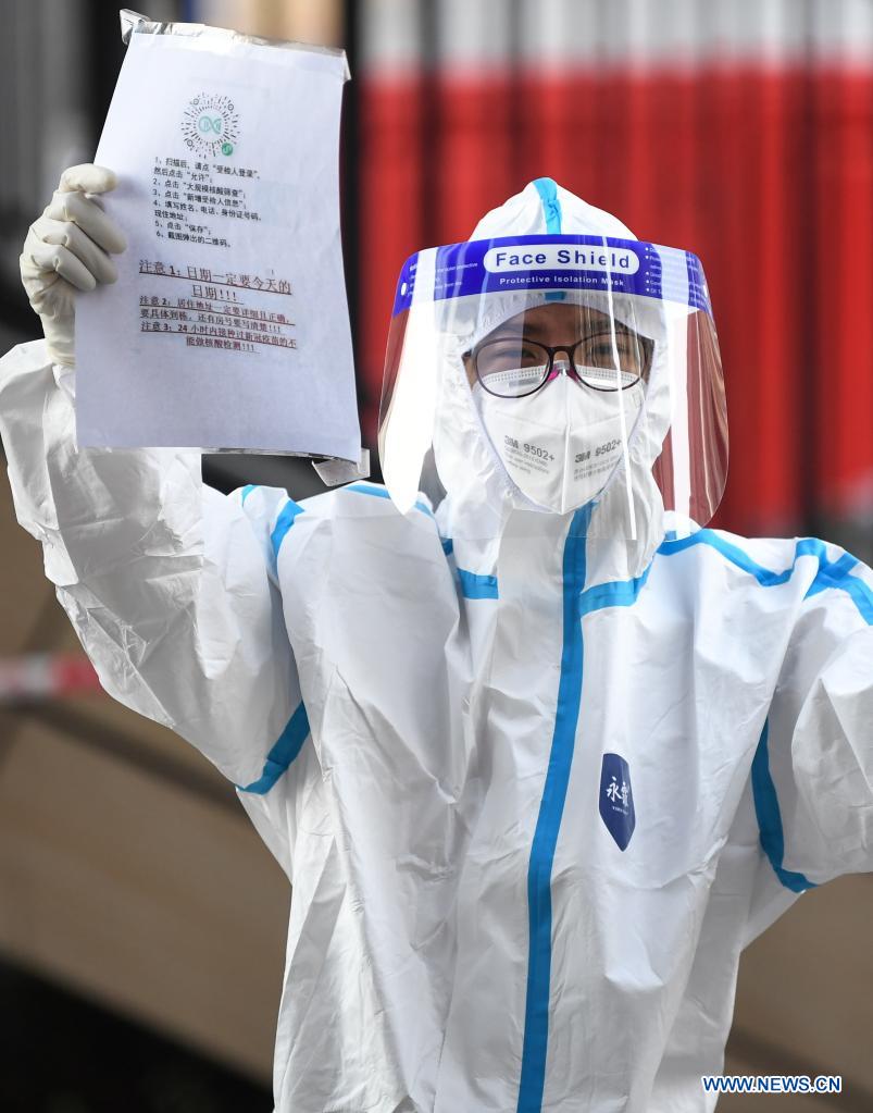 A volunteer reminds residents registering their information on the applet before COVID-19 nucleic acid testing in Liwan District of Guangzhou, south China's Guangdong Province, June 8, 2021. A new round of mass testing in high-risk areas of Baihedong Street and Zhongnan Street in Guangzhou started on Tuesday. (Xinhua/Deng Hua)