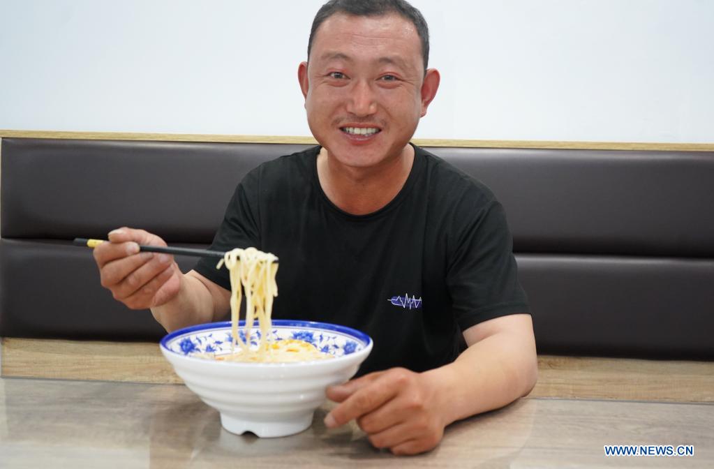 Local farmer Su Chuan has noodles as the day's meal in Xingtai, north China's Hebei Province, June 9, 2021. With the summer wheat harvest underway, farmers in north China's Xingtai have been busy in the fields to reap the year's premium grains. In Xingtai, a total of 65 farmers have joined the Jinshahe specialized cooperative that provides them with technical guidance in crop harvesting. The cooperative will sell freshly harvested crops to a local noodle factory where staple products are made and sold to customers. (Xinhua/Jin Haoyuan)