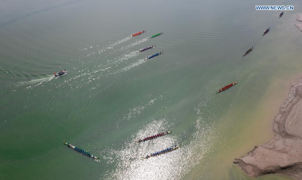 Aerial photo taken on June 14, 2021 shows people participating in a dragon boat race to celebrate the Dragon Boat Festival in Zigui County, central China's Hubei Province. China celebrated the Dragon Boat Festival on Monday to commemorate Qu Yuan, a patriotic poet from the Warring States Period (475-221 BC) believed to have been born in Zigui County. (Photo by Lei Yong/Xinhua)