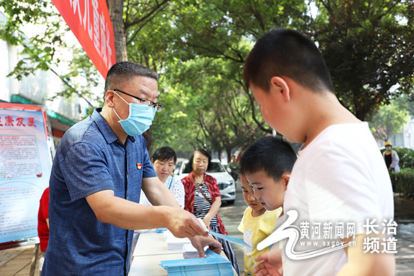 图为:长治市残联副理事长刘文茂向未成年人普法