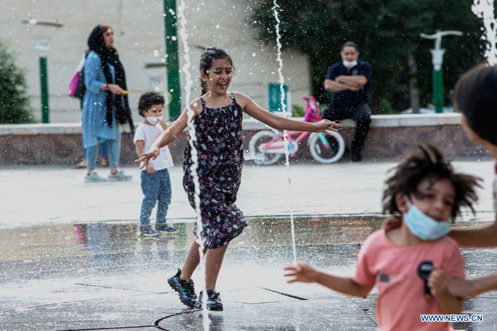 Children cool off at a splash pad during hot weather at a park in Tehran, Iran, on June 29, 2021. (Photo by Ahmad Halabisaz/Xinhua)