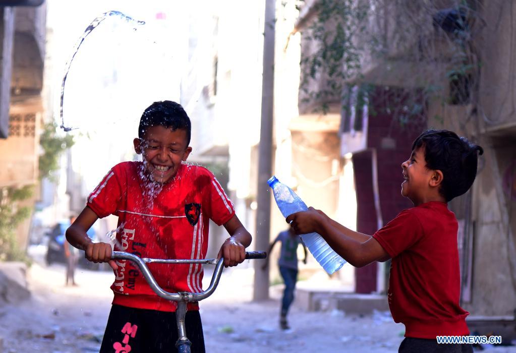 Syrian children cool off with water during hot weather in Damascus, Syria, on June 29, 2021. (Photo by Ammar Safarjalani/Xinhua)