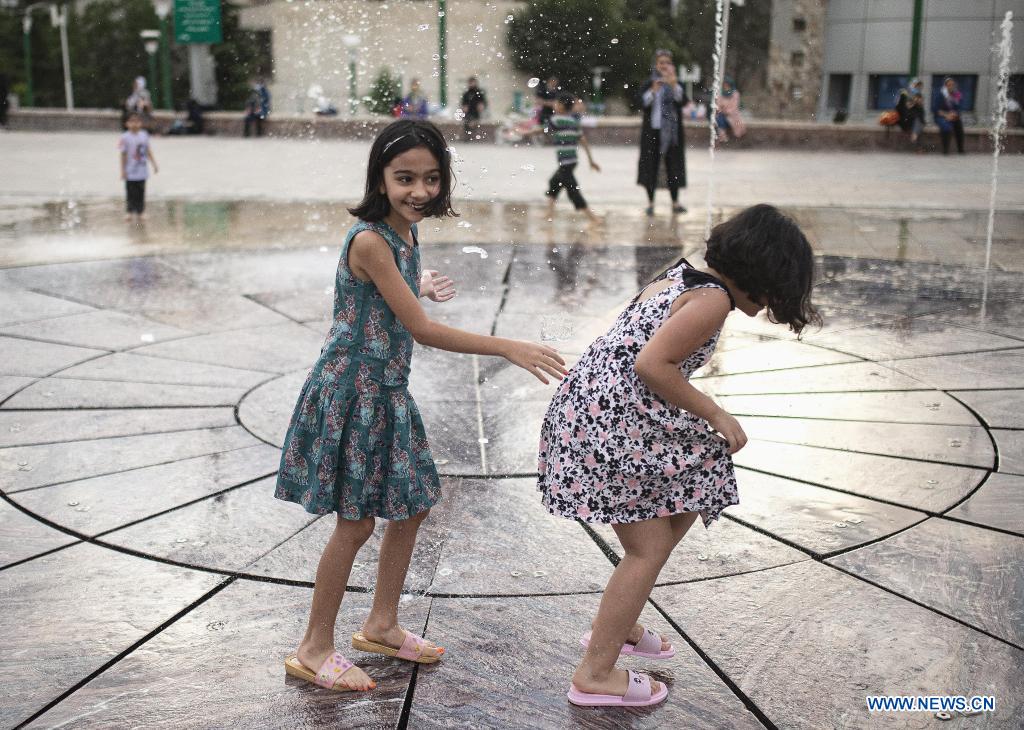 Children cool off at a splash pad during hot weather at a park in Tehran, Iran, on June 29, 2021. (Photo by Ahmad Halabisaz/Xinhua)