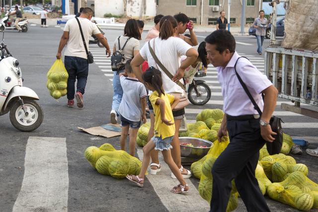 买西瓜的市民很多,一大车西瓜一会儿就卖了一半.