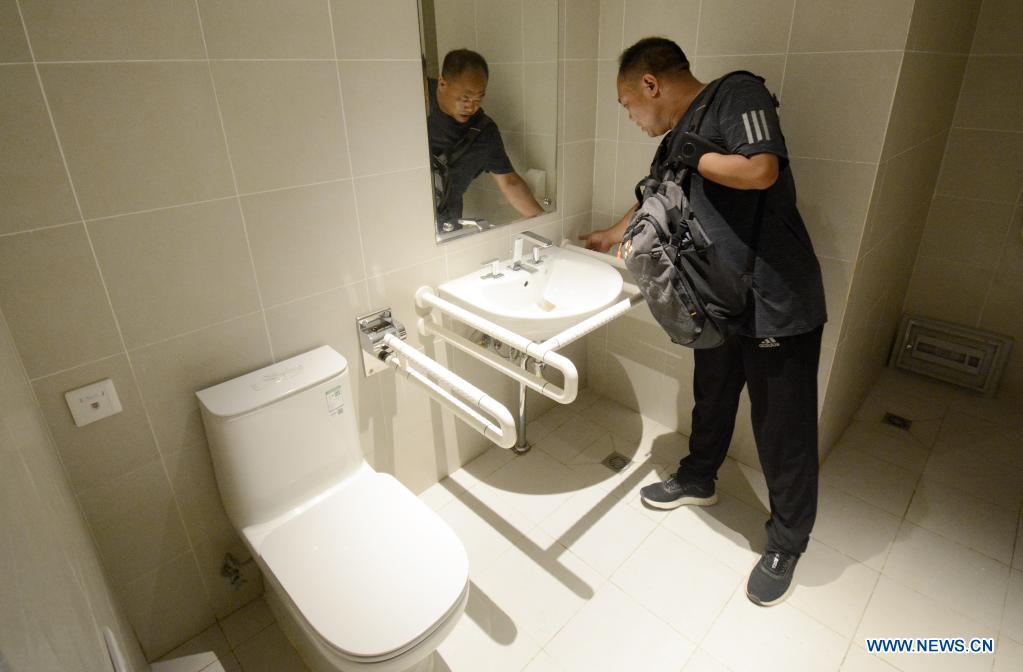 Experts check the barrier-free toilet facilities at the athletes' village for the Beijing 2022 Paralympic Winter Games in Beijing's northwestern Yanqing district, China, July 15, 2021. (Xinhua/Li Xin)