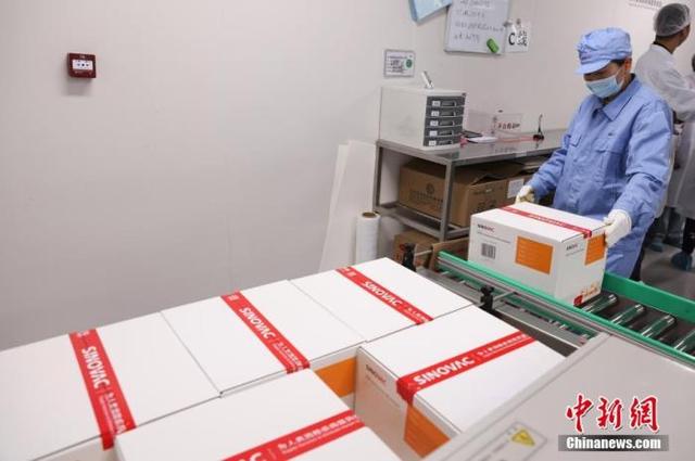 资料图为5月11日,北京大兴,北京科兴中维生物技术有限公司生产车间内,工作人员搬运包装好的疫苗。 中新社记者 蒋启明 摄