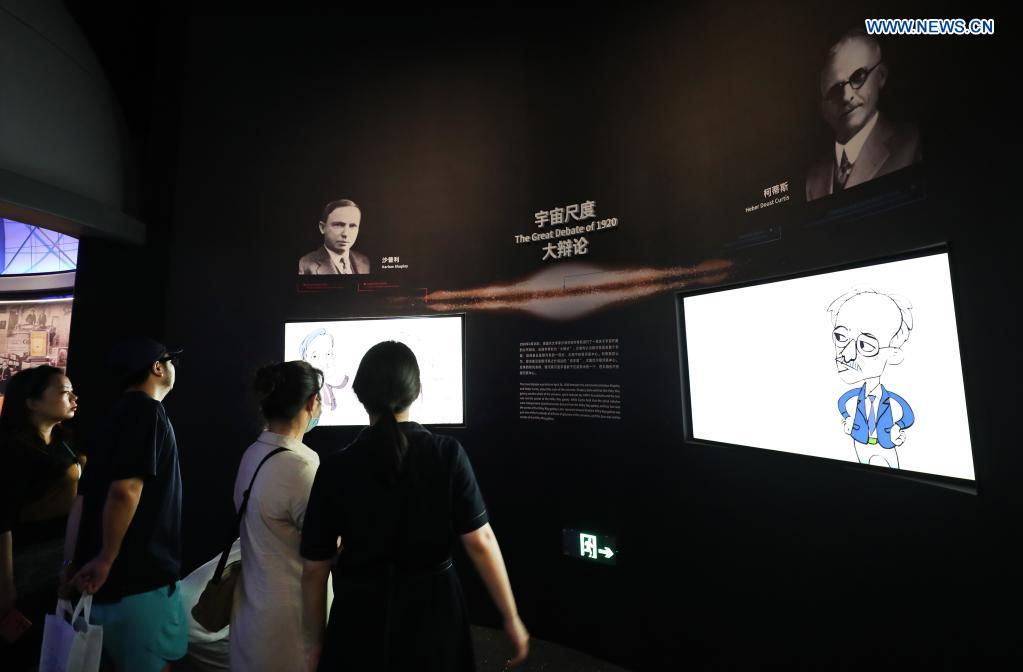 People view an exhibition introducing astronomy theories at the Shanghai Astronomy Museum in east China's Shanghai, July 18, 2021. The Shanghai Astronomy Museum, the world's largest planetarium in terms of building scale, opened to the public on Sunday. Covering an area of approximately 58,600 square meters, the museum is located in the China (Shanghai) Pilot Free Trade Zone Lingang Special Area. It is a branch of the Shanghai Science and Technology Museum. (Xinhua/Fang Zhe)