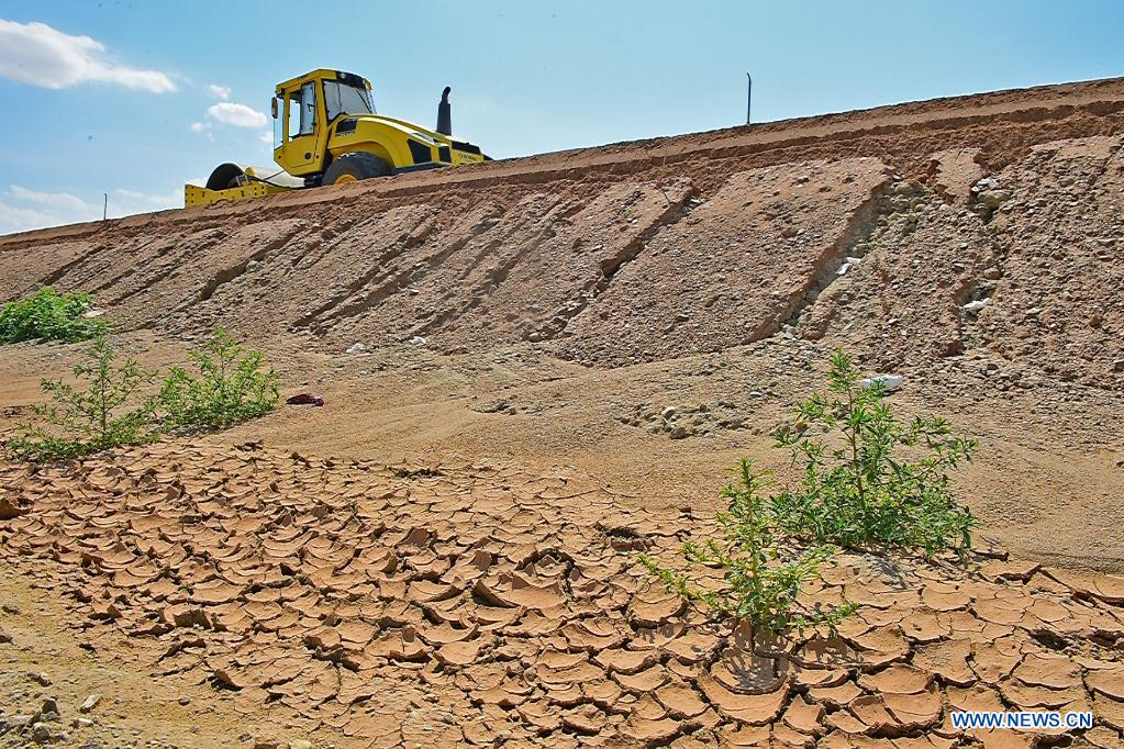 A vehicle paves a section of a cross-desert expressway with asphalt in northwest China's Xinjiang Uygur Autonomous Region, July 16, 2021. Construction of the first cross-desert expressway in Xinjiang has proceeded smoothly. The expressway, linking Altay Prefecture and the regional capital city of Urumqi, stretches some 343 km, with sections of more than 150 km built through the desert. (Xinhua/Hou Zhaokang)