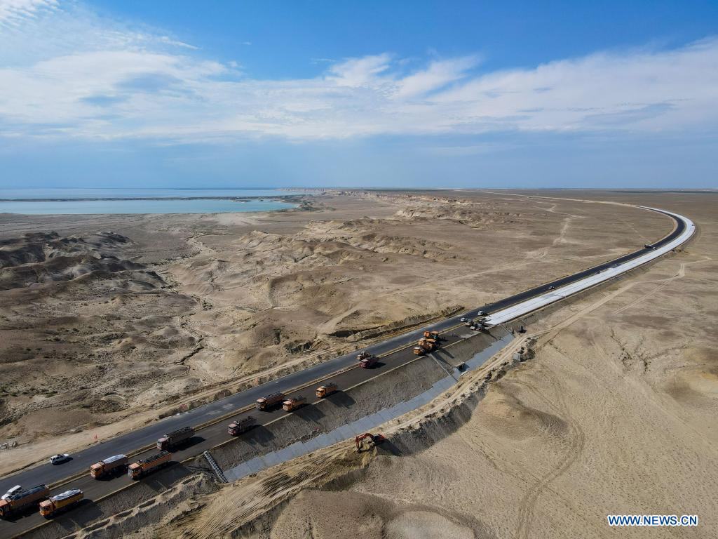 Aerial photo taken on July 16, 2021 shows a construction site of a cross-desert expressway in northwest China's Xinjiang Uygur Autonomous Region. Construction of the first cross-desert expressway in Xinjiang has proceeded smoothly. The expressway, linking Altay Prefecture and the regional capital city of Urumqi, stretches some 343 km, with sections of more than 150 km built through the desert. (Xinhua/Gao Han)