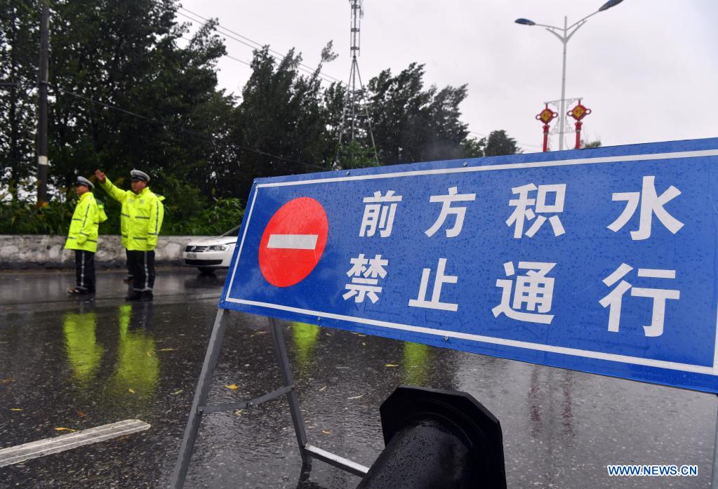 Policemen direct traffic at a waterlogged area in Jiaozuo, central China's Henan Province, July 20, 2021. Rivers in Jiaozuo have witnessed rising water level as continuous rainfalls recently hit the city. Local authorities have organized flood-control workers to patrol the city around the clock and eliminate hidden dangers to protect the safety of people's lives and property. (Xinhua/Li Jianan)