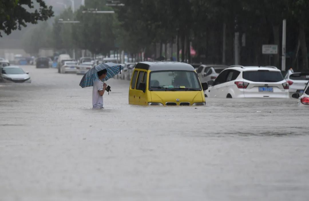 　　△20日,在郑州,行人涉水通过积水路段。