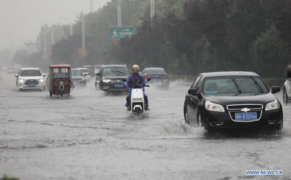 People drive in the rain in Wuzhi County, central China's Henan Province, July 20, 2021. Wuzhi County of Jiaozuo has recently witnessed continuous rainfalls. Flood-control measures such as water draining, patrolling embankments and traffic control were carried out to protect the safety of people's lives and property. (Photo by Feng Xiaomin/Xinhua)