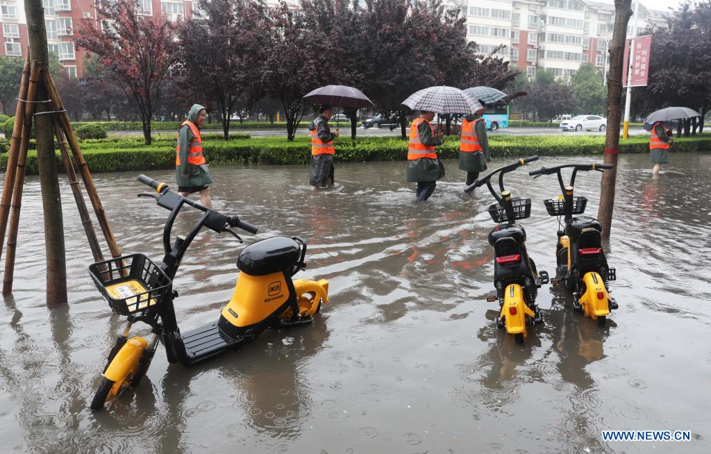 Staff members check a waterlogged area in Wuzhi County, central China's Henan Province, July 20, 2021. Wuzhi County of Jiaozuo has recently witnessed continuous rainfalls. Flood-control measures such as water draining, patrolling embankments and traffic control were carried out to protect the safety of people's lives and property. (Photo by Feng Xiaomin/Xinhua)