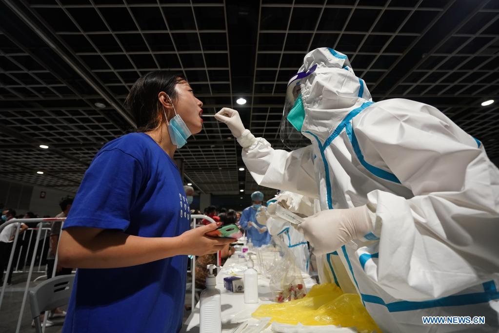 A medical worker takes a swab sample from a woman for COVID-19 test at a testing site in Nanjing, east China's Jiangsu Province, July 21, 2021. Nanjing, which has a population of more than 9.3 million, carried out citywide nucleic acid testing starting on Wednesday. (Xinhua/Ji Chunpeng)