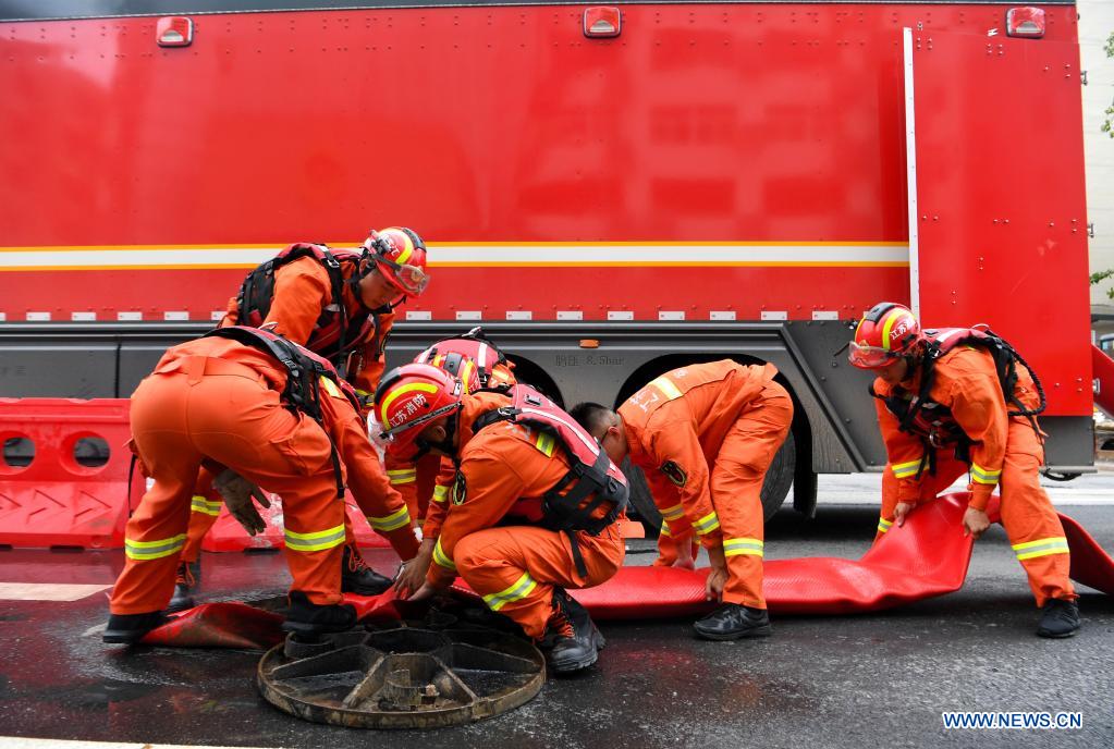 Firefighters put the drainage pipe in place in Zhengzhou, capital of central China's Henan Province, July 21, 2021. Extremely heavy rainfall hit Henan on Tuesday, with precipitation in Zhengzhou, exceeding the highest level on local weather records. A rescue team of 1,800 firefighters has been deployed to the flood-hit region from seven neighboring provinces, together with boats, pumping vehicles, and flood rescue kits. (Xinhua/Hao Yuan)