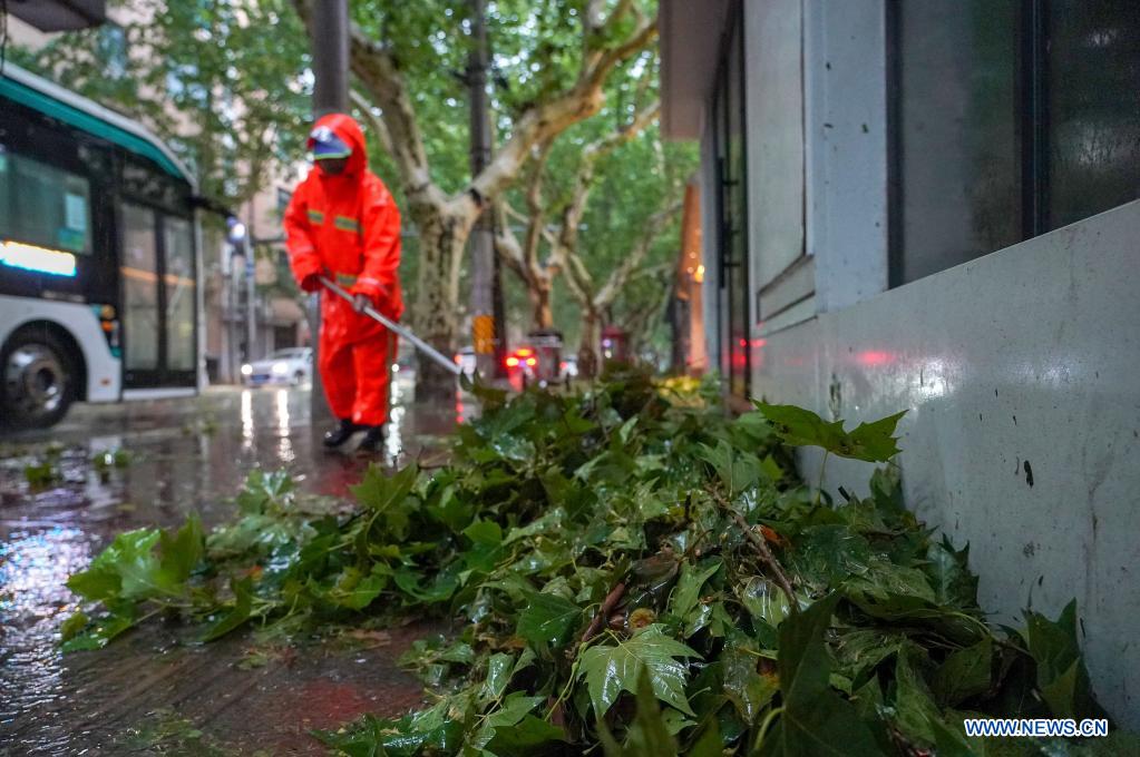 A sanitation worker cleans branches downed by gales in east China's Shanghai, July 25, 2021. Typhoon In-Fa, which made landfall in east China's Zhejiang Province at around Sunday noon, will make another landfall in coastal areas from Pinghu in Zhejiang Province to Pudong in Shanghai, according to the National Meteorological Center. (Xinhua/Wang Xiang)