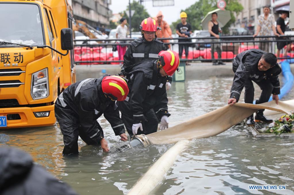 Rescuers prepare to pump rainwater out of a road at a residential area in Zhoushan, east China's Zhejiang Province, July 25, 2021. China's national observatory on Sunday continued its orange alert for Typhoon In-Fa, which made landfall in Zhejiang at around Sunday noon. (Photo by Chen Yongjian/Xinhua)