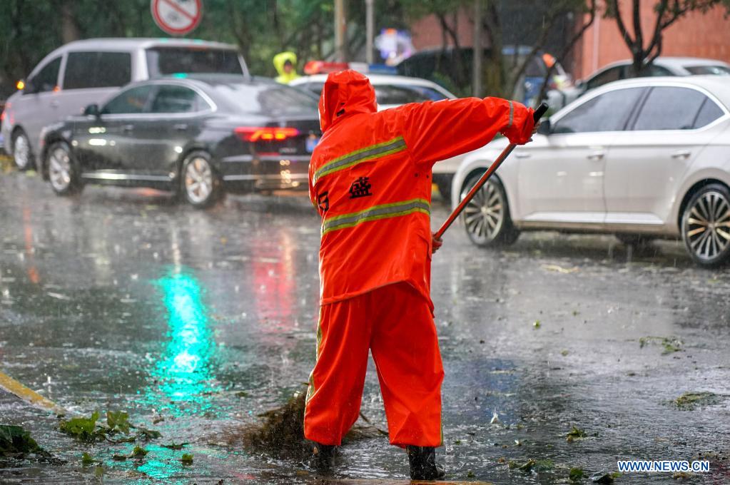 A sanitation worker cleans a road on Hengshan Road, east China's Shanghai, July 25, 2021. Typhoon In-Fa, which made landfall in east China's Zhejiang Province at around Sunday noon, will make another landfall in coastal areas from Pinghu in Zhejiang Province to Pudong in Shanghai, according to the National Meteorological Center. (Xinhua/Wang Xiang)