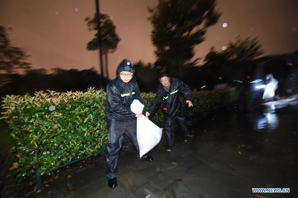 Staff pile sandbags to prevent flood at a park in Pinghu, Jiaxing, east China's Zhejiang Province, July 25, 2021. China's national observatory on Sunday continued its orange alert for Typhoon In-Fa, which made landfall in Zhejiang at around Sunday noon. Moving northwestward at about 10 km per hour, In-Fa will make another landfall in coastal areas from Pinghu in Zhejiang Province to Pudong in Shanghai, according to the National Meteorological Center. (Xinhua/Xu Yu)