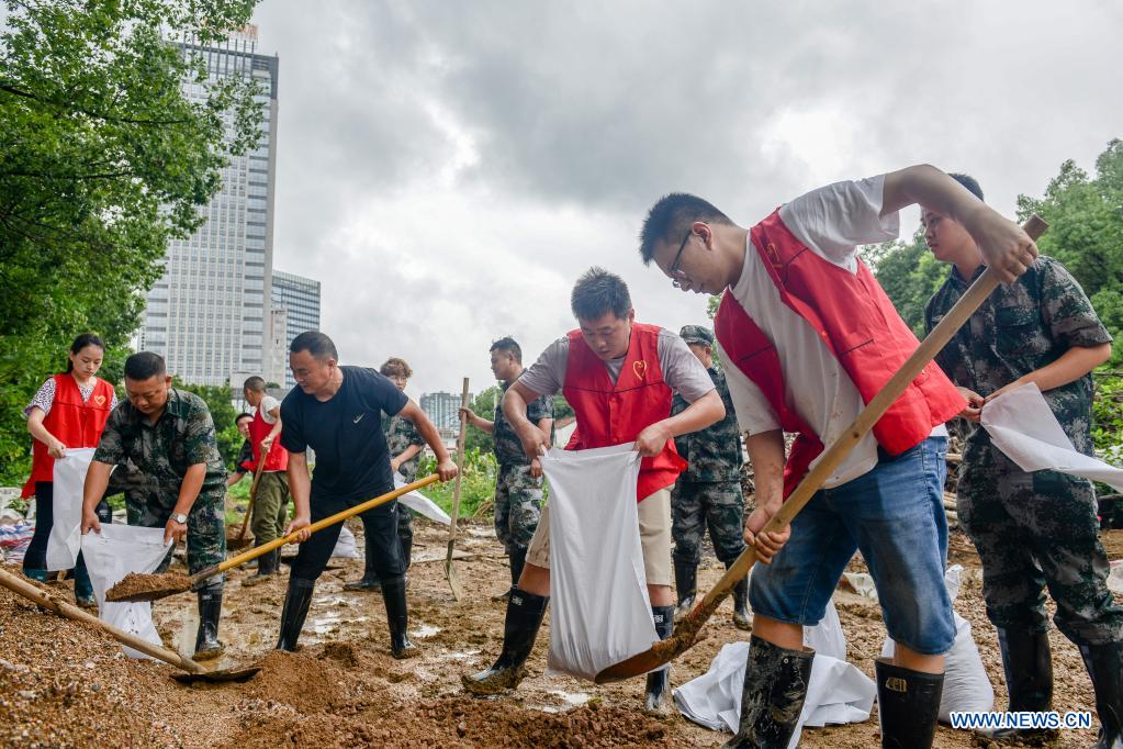 People fill up sandbags to reinforce river banks in Changxing County of Huzhou City, east China's Zhejiang Province, July 25, 2021. China's national observatory on Sunday continued its orange alert for Typhoon In-Fa, which made landfall in Zhejiang at around Sunday noon. (Photo by Wu Zheng/Xinhua)