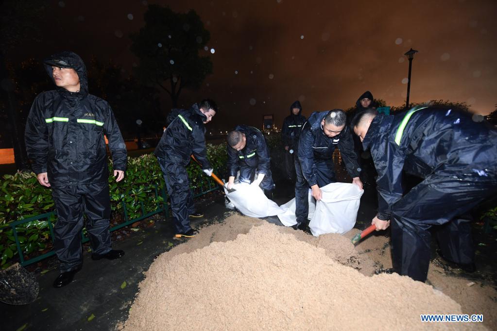 Staff pile sandbags to prevent flood at a park in Pinghu, Jiaxing, east China's Zhejiang Province, July 25, 2021. China's national observatory on Sunday continued its orange alert for Typhoon In-Fa, which made landfall in Zhejiang at around Sunday noon. Moving northwestward at about 10 km per hour, In-Fa will make another landfall in coastal areas from Pinghu in Zhejiang Province to Pudong in Shanghai, according to the National Meteorological Center. (Xinhua/Xu Yu)