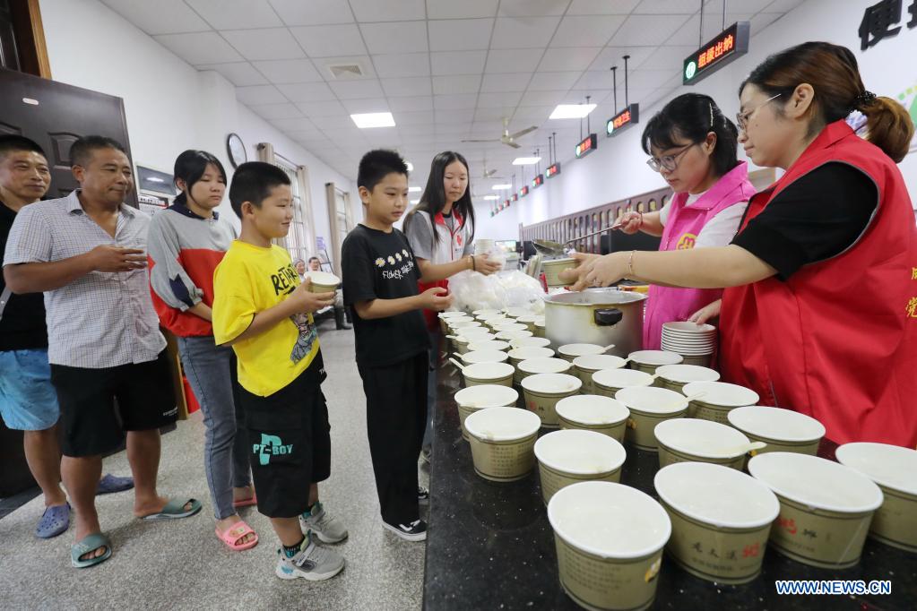 Volunteers send breakfast to people who have been evacuated to a temporary shelter in Shangbai Village, Deqing County of Huzhou City, east China's Zhejiang Province, July 25, 2021. China's national observatory on Sunday continued its orange alert for Typhoon In-Fa, which made landfall in Zhejiang at around Sunday noon. (Photo by Xie Shangguo/Xinhua)