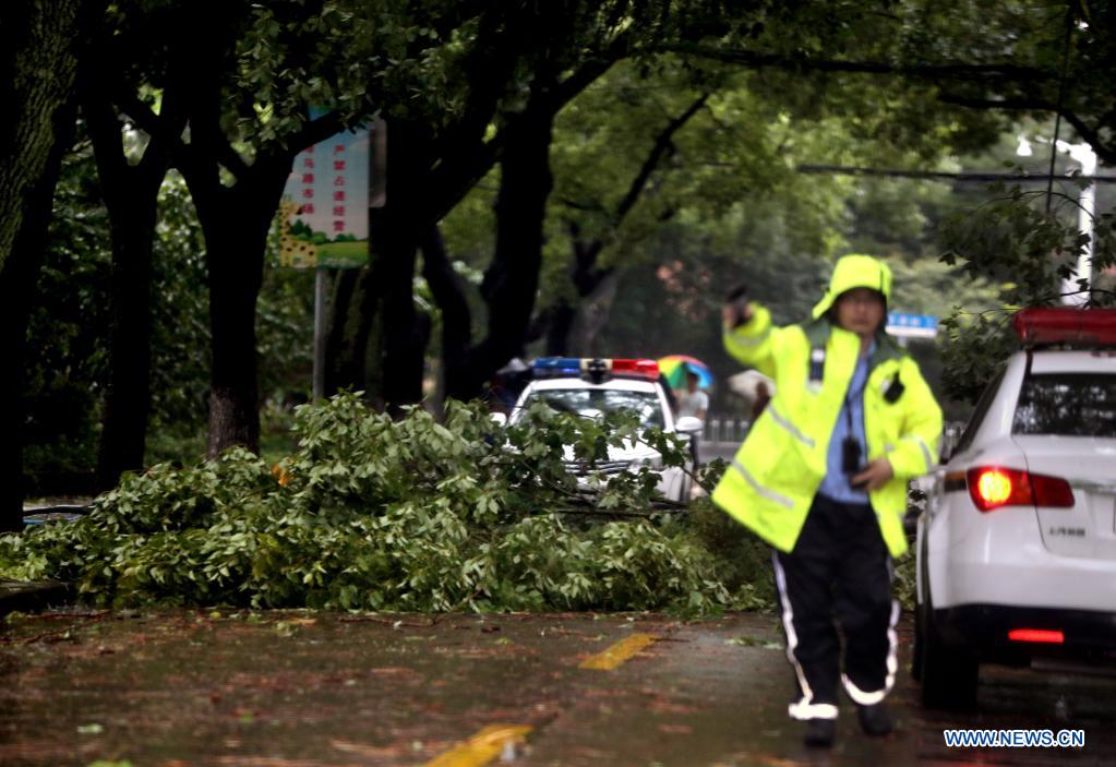 A traffic policeman directs the traffic in Minhang District in east China's Shanghai, July 25, 2021. Typhoon In-Fa, which made landfall in east China's Zhejiang Province at around Sunday noon, will make another landfall in coastal areas from Pinghu in Zhejiang Province to Pudong in Shanghai, according to the National Meteorological Center. (Xinhua/Liu Ying)