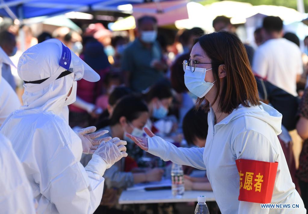 A doctor talks to a volunteer at a COVID-19 testing site in Jiangning District of Nanjing, capital of east China's Jiangsu Province, July 21, 2021. Nanjing, a mega-city with a population of more than 9.3 million, has launched a second round of all-inclusive nucleic acid testing and urged residents not to leave the city unless necessary. (Xinhua/Ji Chunpeng)