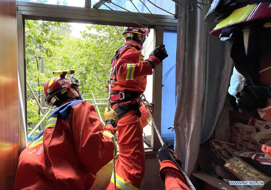 Firefighters remove a loose fence off a window caused by gales in a resident's house in east China's Shanghai, July 25, 2021. Typhoon In-Fa, which made landfall in east China's Zhejiang Province at around Sunday noon, will make another landfall in coastal areas from Pinghu in Zhejiang Province to Pudong in Shanghai, according to the National Meteorological Center. (Xinhua/Chen Fei)