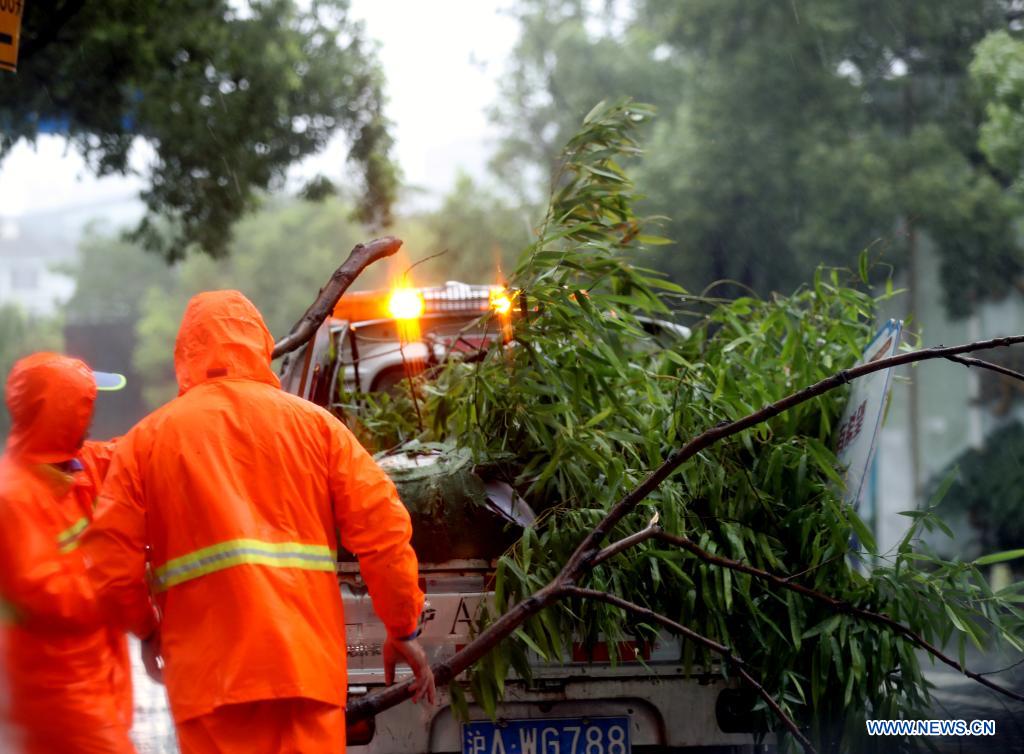 Sanitation workers clean branches downed by gales in east China's Shanghai, July 25, 2021. Typhoon In-Fa, which made landfall in east China's Zhejiang Province at around Sunday noon, will make another landfall in coastal areas from Pinghu in Zhejiang Province to Pudong in Shanghai, according to the National Meteorological Center. (Xinhua/Liu Ying)