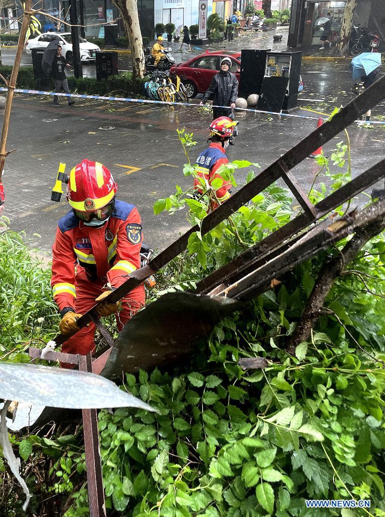 Firefighters remove trees and branches downed by gales in Dingxi Road, east China's Shanghai, July 25, 2021. Typhoon In-Fa, which made landfall in east China's Zhejiang Province at around Sunday noon, will make another landfall in coastal areas from Pinghu in Zhejiang Province to Pudong in Shanghai, according to the National Meteorological Center. (Xinhua/Chen Fei)