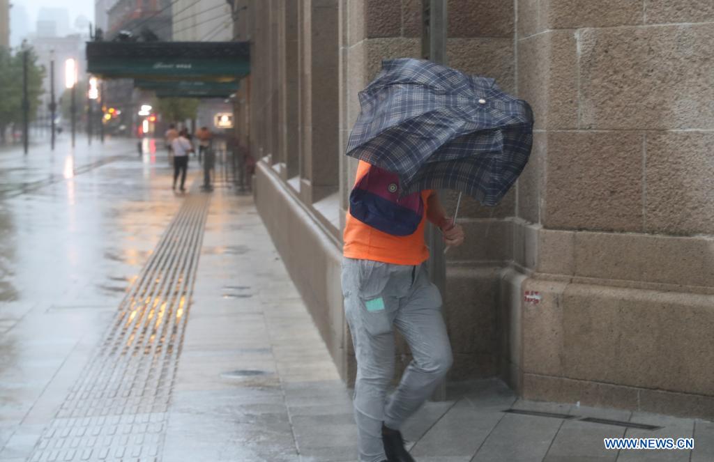 A pedestrian walks against gales on a road in Minhang District in east China's Shanghai, July 25, 2021. Typhoon In-Fa, which made landfall in east China's Zhejiang Province at around Sunday noon, will make another landfall in coastal areas from Pinghu in Zhejiang Province to Pudong in Shanghai, according to the National Meteorological Center. (Xinhua/Fang Zhe)